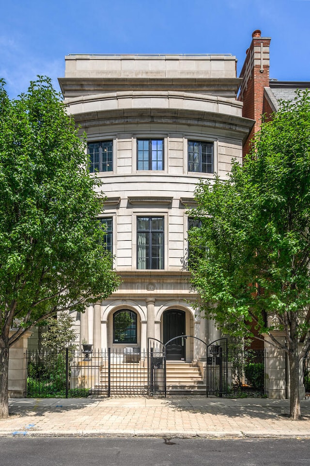 460 W Huron St, Chicago, IL 60654 - view of front of house featuring a gate, a fenced front yard, and stone siding