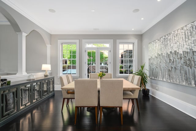 dining space featuring dark hardwood / wood-style flooring, ornate columns, and crown molding