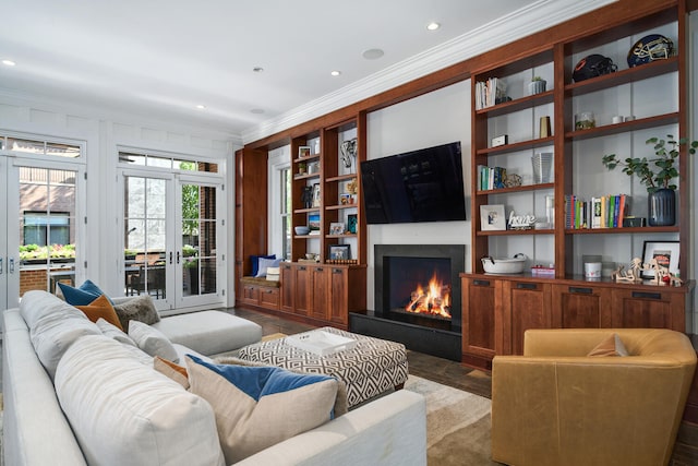 living room featuring french doors, built in features, ornamental molding, and wood-type flooring