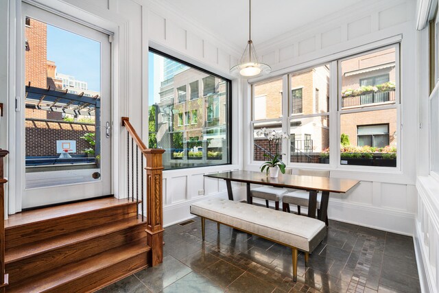 460 W Huron St, Chicago, IL 60654 - dining space featuring a decorative wall, stairway, crown molding, and stone tile flooring