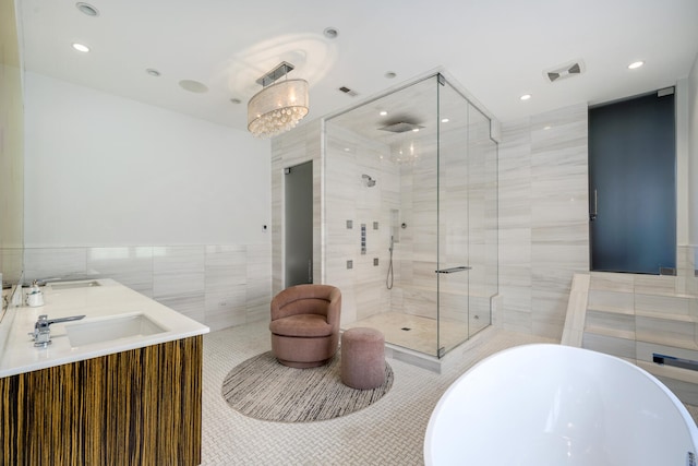 bathroom featuring tile patterned floors, vanity, tile walls, a notable chandelier, and shower with separate bathtub