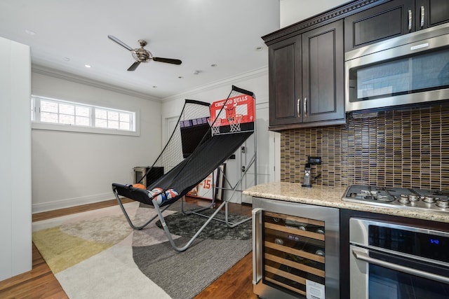 interior space featuring tasteful backsplash, ornamental molding, stainless steel appliances, beverage cooler, and dark wood-type flooring