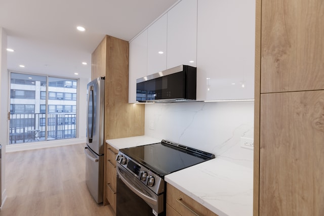 kitchen featuring light stone countertops, stainless steel appliances, light hardwood / wood-style floors, decorative backsplash, and white cabinets