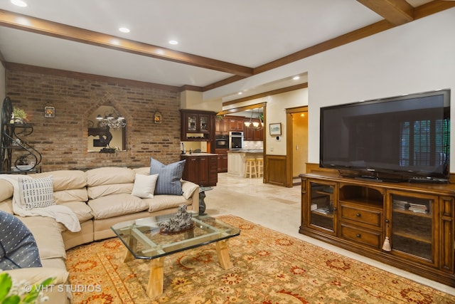 living room featuring beamed ceiling and brick wall