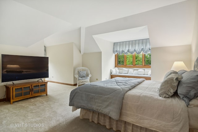 bedroom featuring light carpet and lofted ceiling