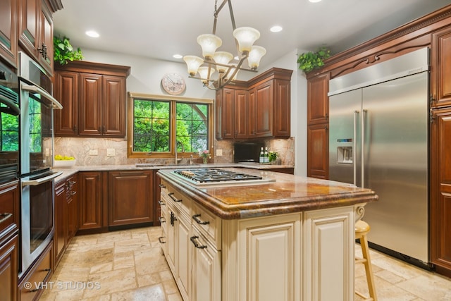 kitchen featuring a breakfast bar, decorative backsplash, a notable chandelier, a kitchen island, and stainless steel appliances