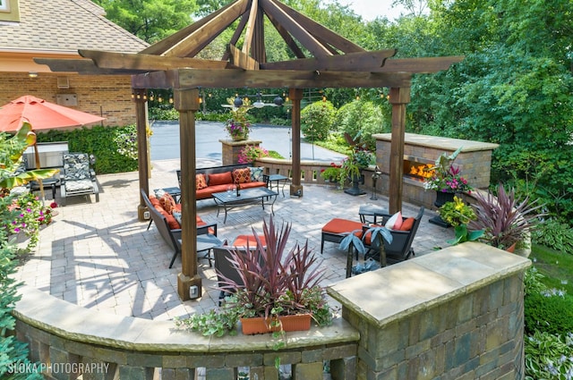 view of patio featuring an outdoor living space with a fireplace and a pergola