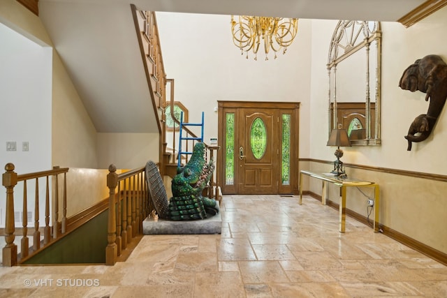 entrance foyer with a chandelier and ornamental molding