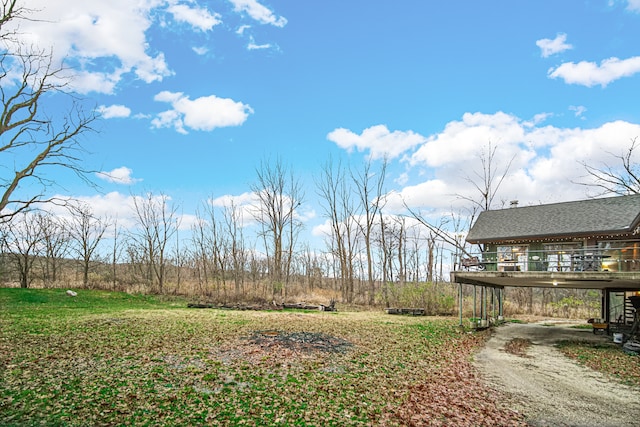 view of yard with a carport and a wooden deck