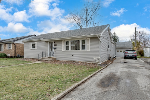 view of front of house with a front yard, an outdoor structure, and a garage