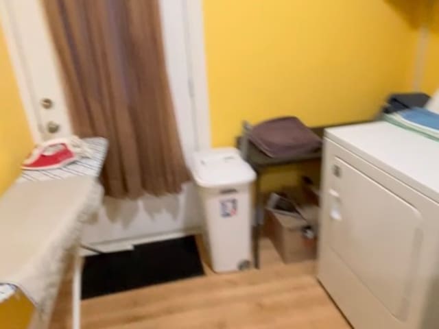 laundry room featuring washing machine and dryer and light wood-type flooring