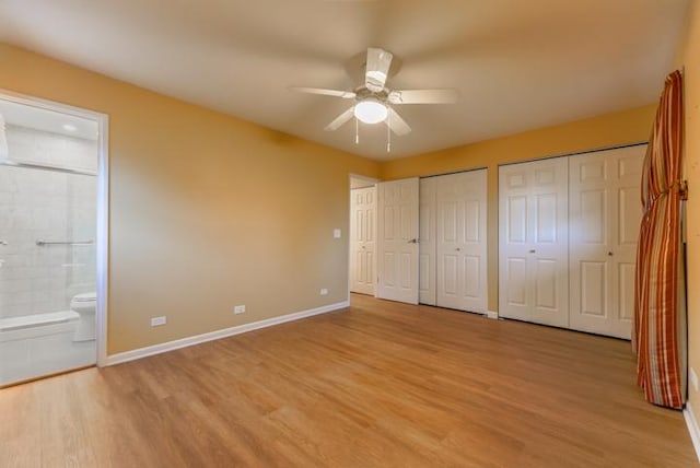 unfurnished bedroom with ensuite bathroom, two closets, ceiling fan, and light hardwood / wood-style flooring