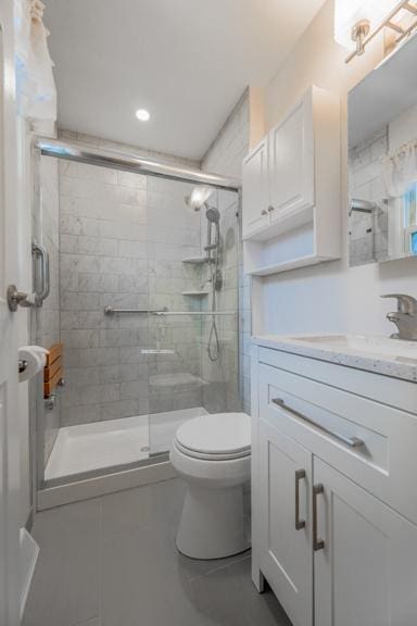 bathroom featuring vanity, toilet, and an enclosed shower