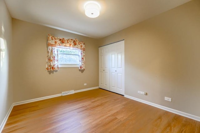 unfurnished bedroom featuring hardwood / wood-style floors and a closet