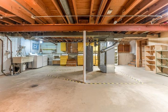 basement featuring sink, washing machine and dryer, heating unit, and gas water heater