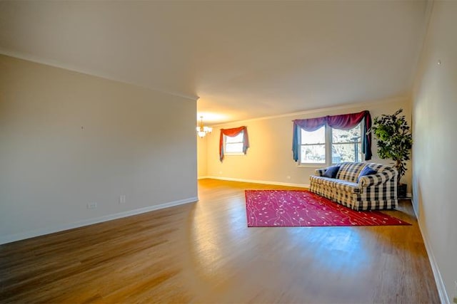 unfurnished living room with crown molding, hardwood / wood-style floors, and a chandelier