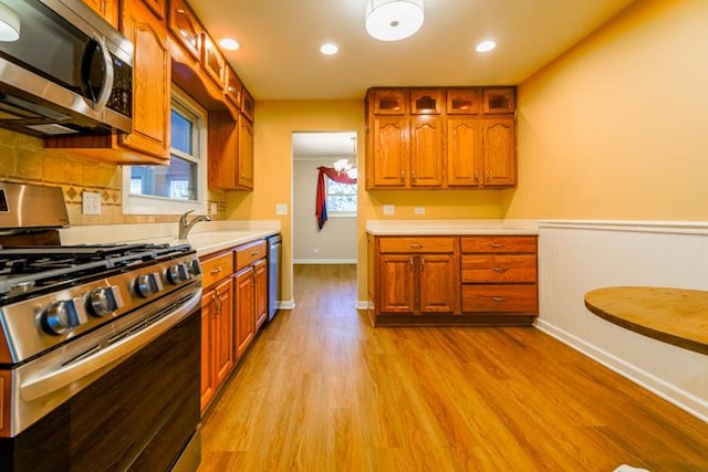 kitchen featuring appliances with stainless steel finishes, sink, and light wood-type flooring