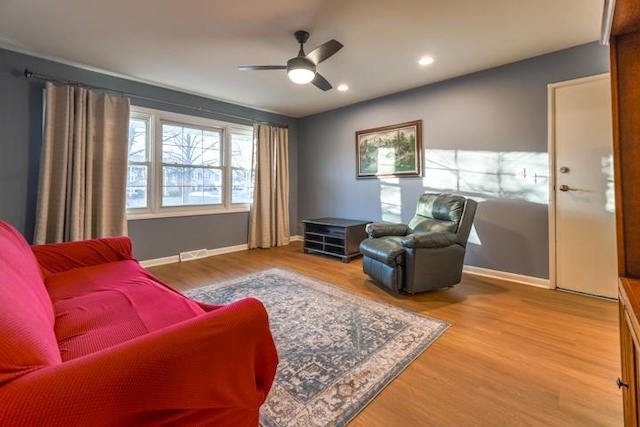 living room featuring wood-type flooring and ceiling fan