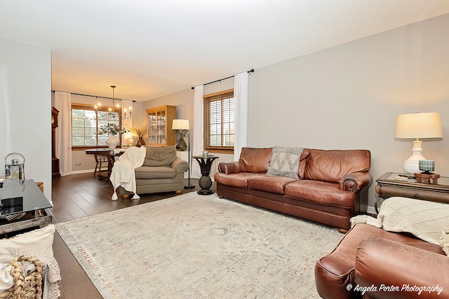 living room with dark hardwood / wood-style flooring and an inviting chandelier