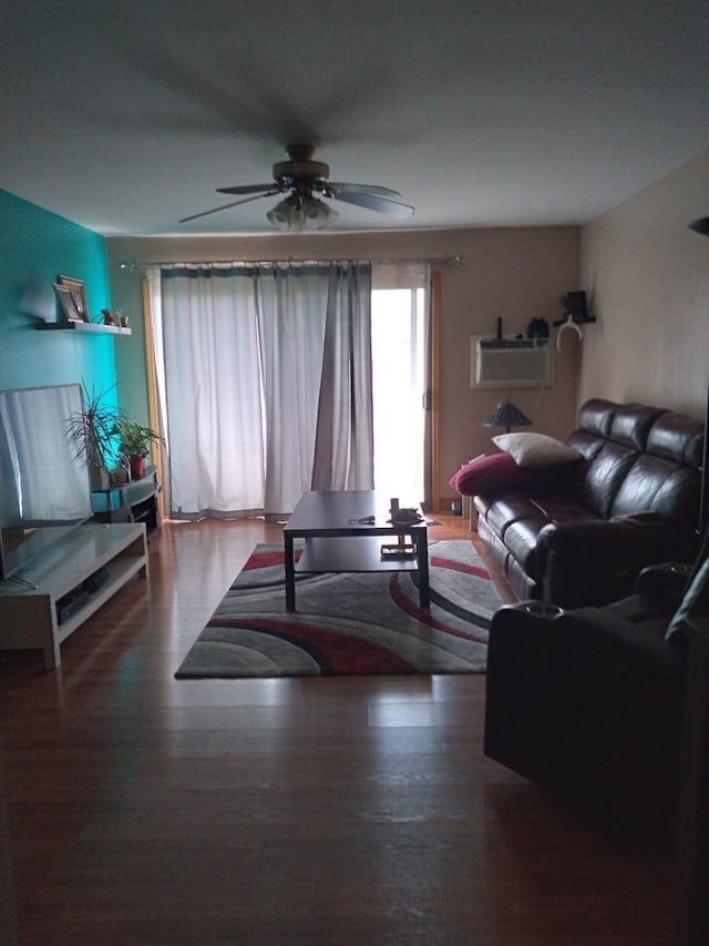 living room featuring wood-type flooring, an AC wall unit, and ceiling fan