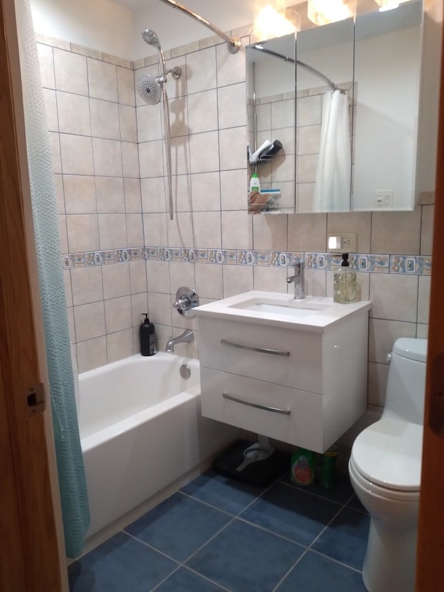 full bathroom with tile patterned flooring, tile walls, toilet, vanity, and shower / tub combo