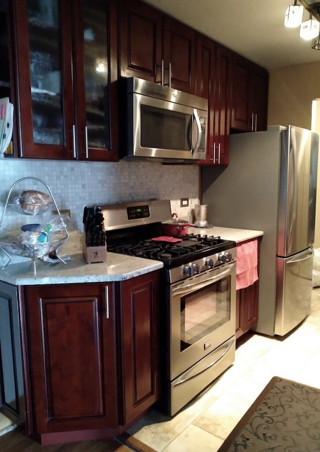 kitchen featuring appliances with stainless steel finishes, backsplash, and light tile patterned floors