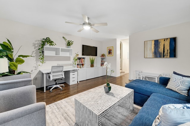 living room featuring ceiling fan and dark wood-type flooring