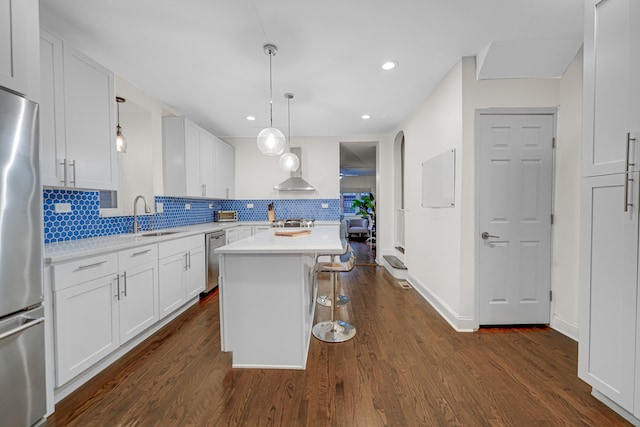 kitchen with a center island, stainless steel appliances, white cabinetry, and dark wood-type flooring