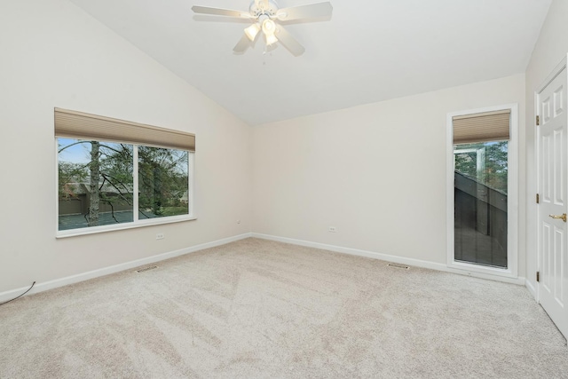 empty room with light colored carpet, a wealth of natural light, and lofted ceiling