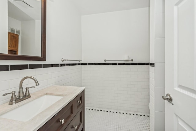 bathroom featuring vanity and tile walls