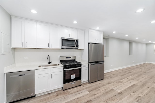 kitchen with white cabinetry, sink, light wood-type flooring, and appliances with stainless steel finishes