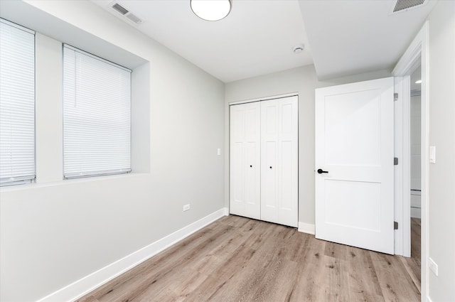 unfurnished bedroom featuring light wood-type flooring and a closet