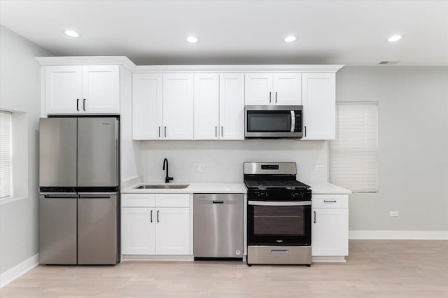 kitchen featuring light hardwood / wood-style flooring, stainless steel appliances, white cabinetry, and sink