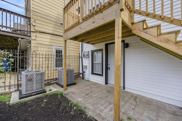 view of exterior entry with cooling unit and a patio area