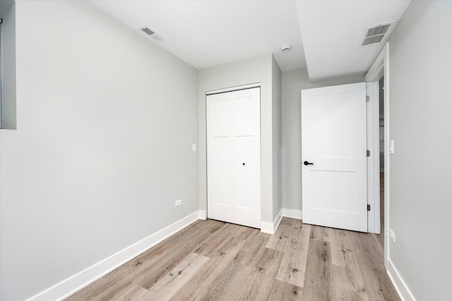 unfurnished bedroom featuring light hardwood / wood-style flooring and a closet