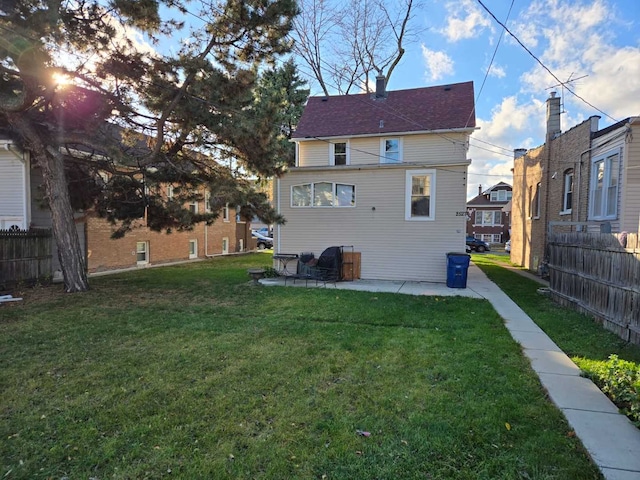 rear view of house with a yard and a patio area