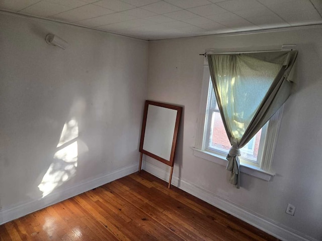 empty room with hardwood / wood-style flooring and a paneled ceiling