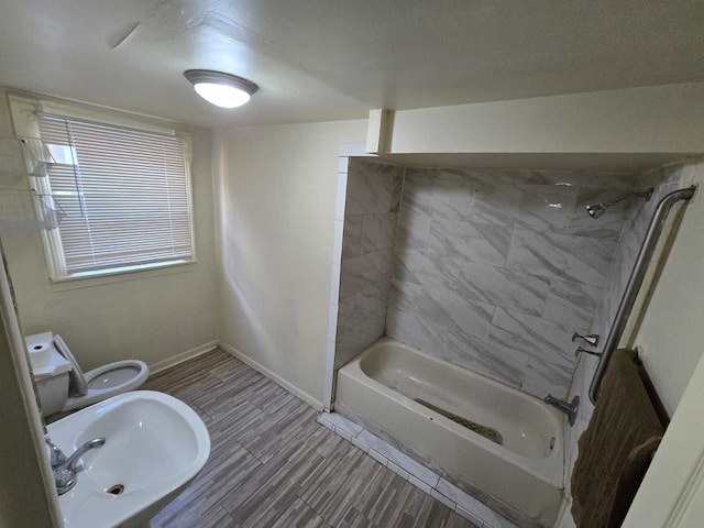 bathroom featuring toilet and tiled shower / bath