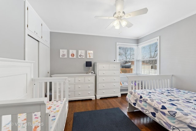 bedroom with ceiling fan, dark wood-type flooring, and a closet