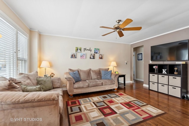 living room featuring dark wood-type flooring, ornamental molding, a healthy amount of sunlight, and ceiling fan