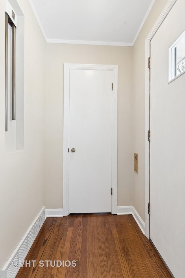 entryway with ornamental molding and wood-type flooring