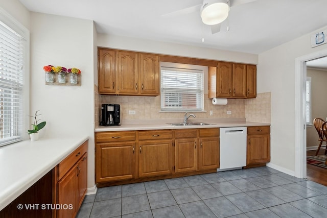 kitchen featuring light tile patterned floors, dishwasher, backsplash, and sink