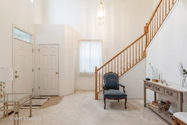 carpeted entryway featuring a high ceiling and a healthy amount of sunlight