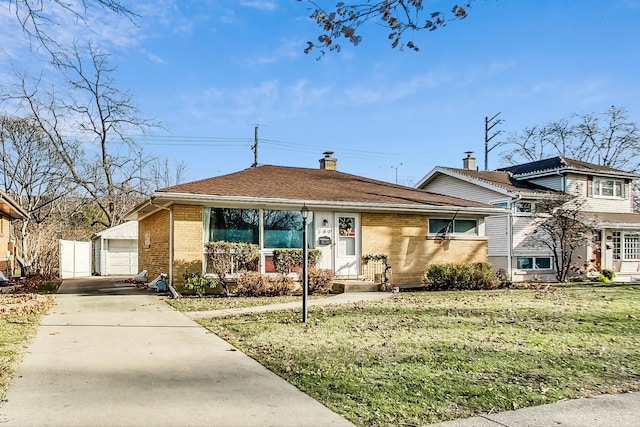 view of front of property featuring an outbuilding, a front lawn, and a garage