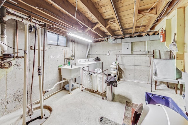 basement with washing machine and clothes dryer and electric panel