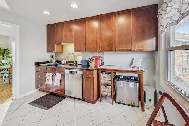 kitchen with a wealth of natural light, dishwasher, light tile patterned floors, and sink