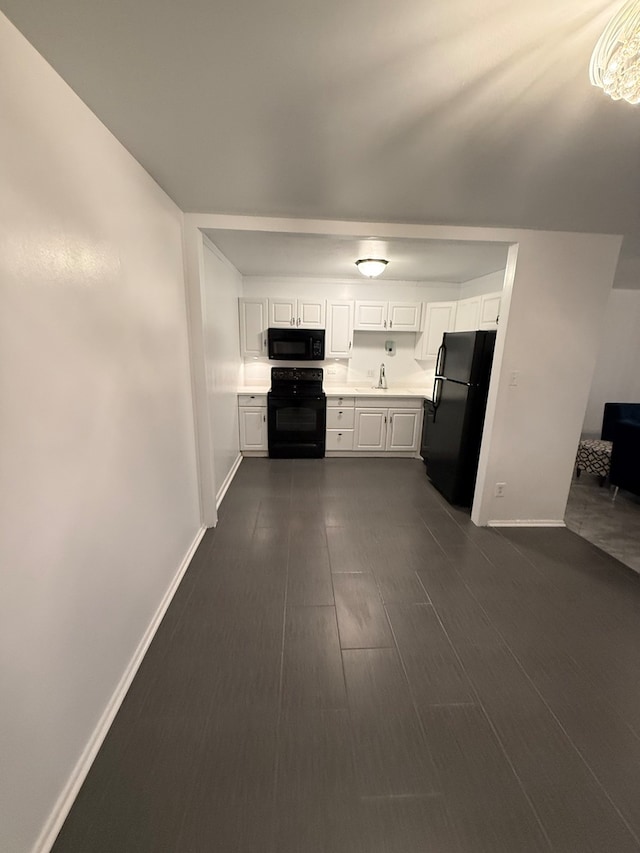 kitchen featuring black appliances, sink, white cabinetry, and dark wood-type flooring