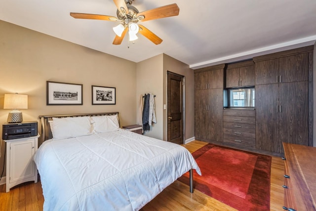 bedroom featuring a ceiling fan, baseboards, and wood finished floors