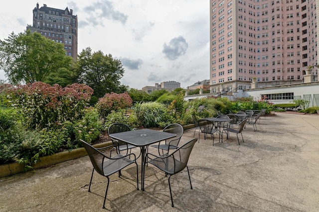 view of patio / terrace with outdoor dining area and a view of city