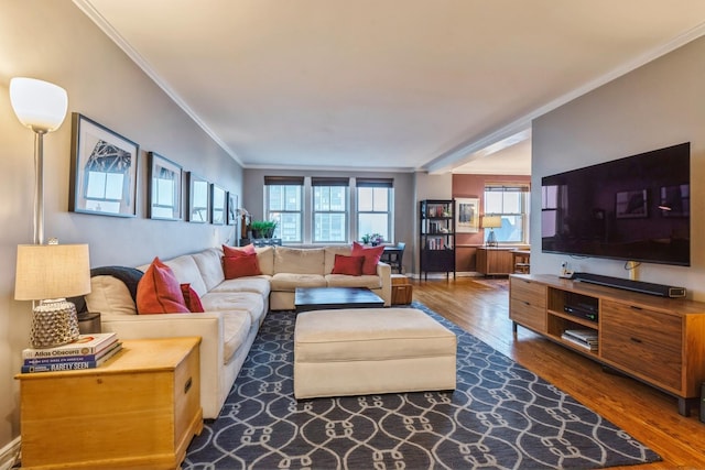 living area with ornamental molding and dark wood-type flooring
